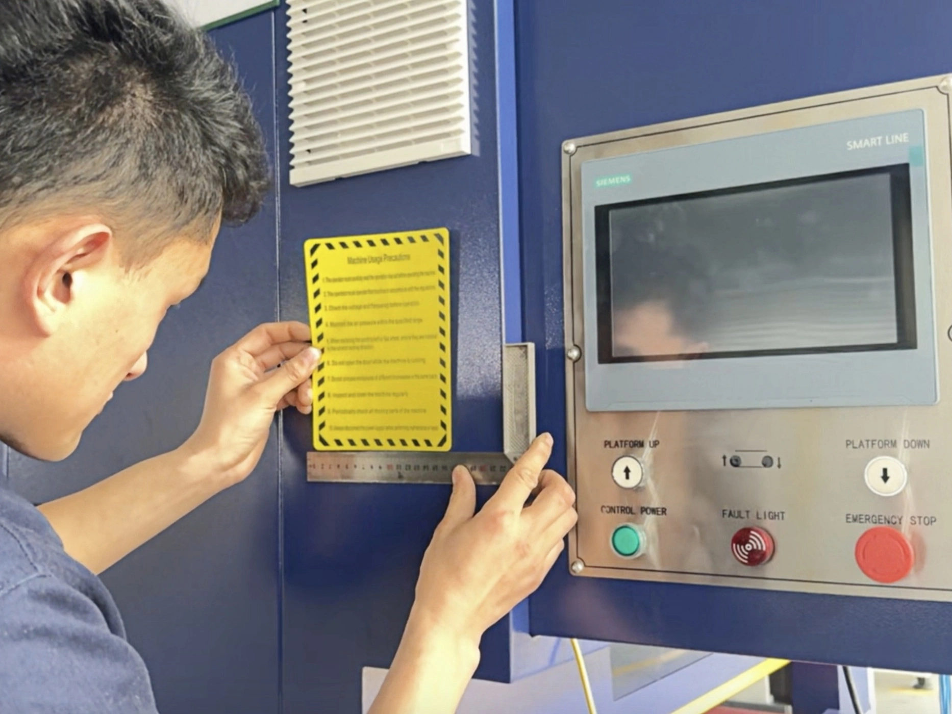 Technician inspecting the touchscreen and buttons on a machine control panel