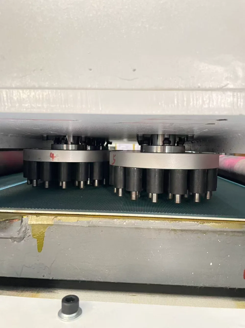 Close-up of rotary tools mounted above the conveyor inside a slag removal machine